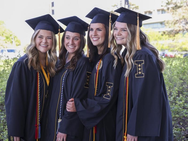 Four students in graduation attire