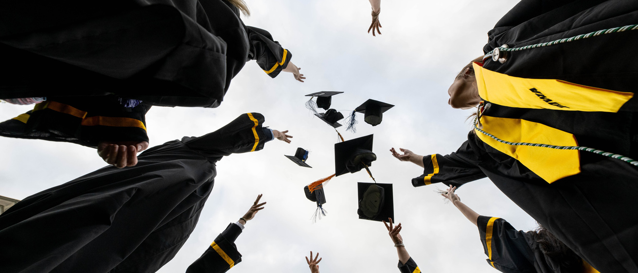 Students throwing cap and gowns in the air