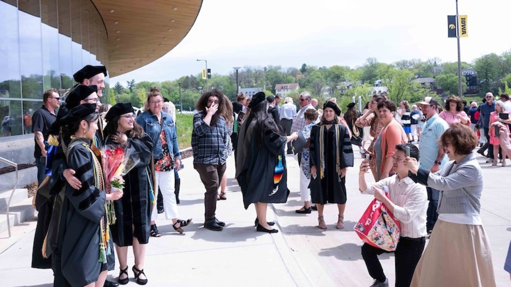 Guests taking photos with graduates at Hancher